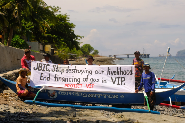 Local fishers in Batangas carry a banner protesting against fossil fuel financing by JBIC