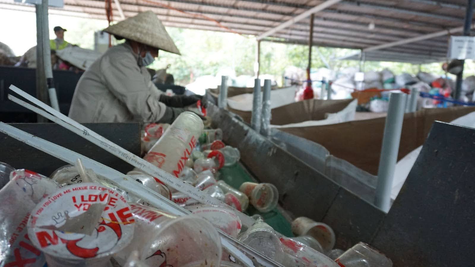 Informal waste worker toils surrounded by plastic waste